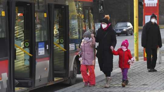 Matka s deťmi nastupuje do autobusu