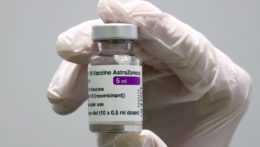 zdravotník ukazuje ampulku s vakcínou od spoločnosti AstraZeneca