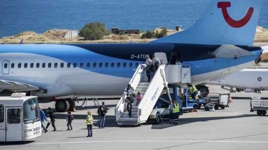 Dovolenkári vystupujú z lietadla na gréckom ostrove Kréta.
