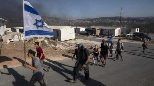 Izraelskí osadníci nesú vlajku na základni Eviatar neďaleko mesta Nábul na Západnom brehu.