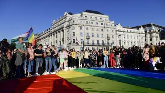 ľudia s dúhovou vlajkou na proteste za práva LGBT komunity v Maďarsku