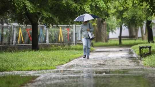 žena kráča s dáždnikom v bratislavskej mestskej časti Ružinov.
