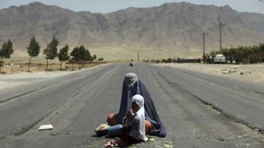 Žena s dieťaťom na ceste neďaleko Kábulu.