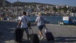 Turisti s batožinou v prístave.