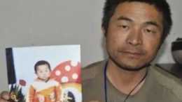 muž s fotografiou svojho uneseného syna