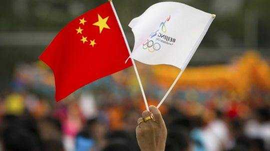 Žena drží čínsku a olympijskú zástavu Peking 2022