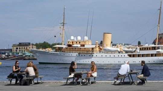 Ľudia na letnej terase kaviarne v prístave v Kodani.