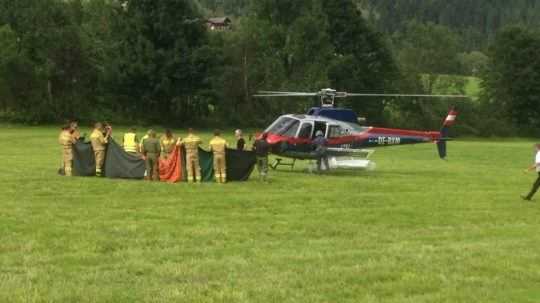Záchranári vedľa polcajného vrtuľníka v rakúskych Alpách.
