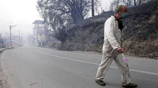 Alžírčan opúšťa dedinu zasiahnutú požiarmi.