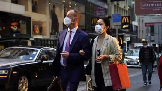 Ľudia s ochrannými rúškami v Hongkongu.