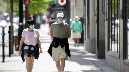 Ľudia s ochrannými rúškami na ulici v Montreale.