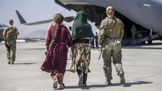 ľudia kráčajú k evakuačnému letu z Kábulu