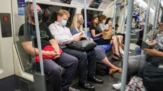 ľudia s rúškami v metre