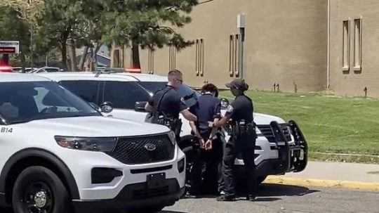 Polícia odvádza 13-ročného chlapca po streľbe na škole v USA.
