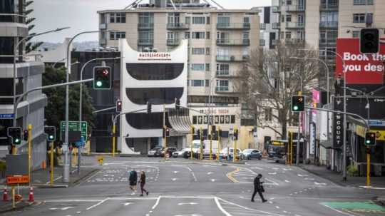 Ľudia prechádzajú cez takmer prázdne ulice v novozélandskom meste Auckland