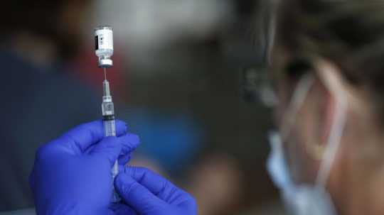 Zdravotná sestra pripravuje ampulku s vakcínou