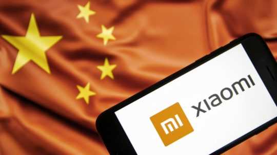 mobilný telefón Xiaomi na pozadí čínskej vlajky