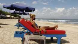 žena sedí na ležadle na jednej z pláží ostrova Bali