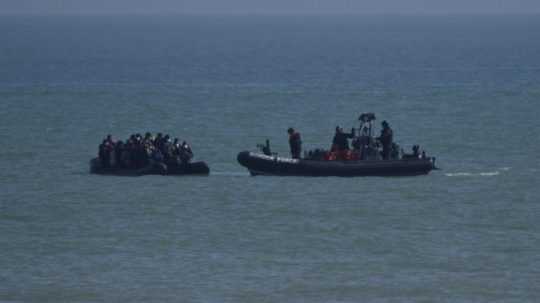 Plavidlo britskej pohraničnej stráže sa približuje k migrantom na nafukovacom člne vo vodách Lamanšského prielivu