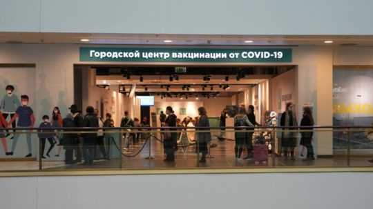 Ľudia stoja v rade na očkovanie proti ochoreniu COVID-19 vo vakcinačnom centre v priestoroch obchodného domu v Petrohrade.