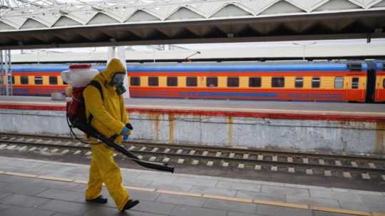 štátny pracovník dezinfikuje priestory železničnej stanice v Moskve