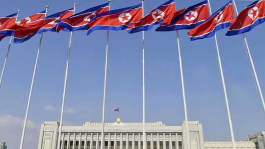 Vlajky KĽDR pred parlamentom v Pchjongjangu