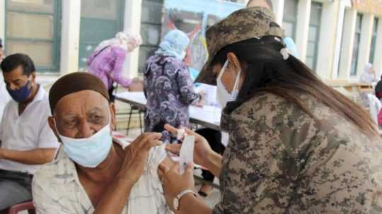 Vojačka očkuje vakcínou proti ochoreniu COVID-19 od spoločnosti AstraZeneca na predmestí hlavného mesta Tunis
