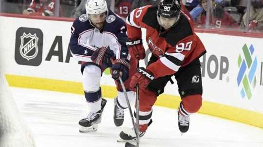 Útočník New Jersey Devils Tomáš Tatar korčuľuje s pukom pred hráčom Columbusu.