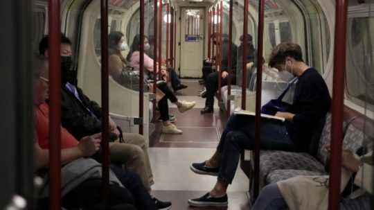 Ľudia s ochrannými rúškami cestujú metrom v Londýne