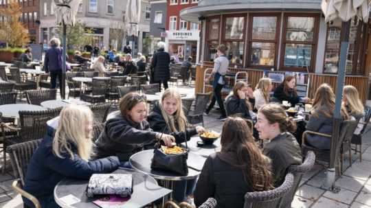 ľudia sedia na terase reštaurácie v dánskom Roskilde