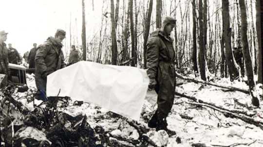 Na archívnej snímke vojaci odnášajú jednu z obetí havárie.