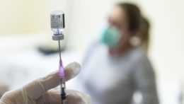zdravotná sestra naťahuje z ampulky do injekčnej striekačky vakcínu proti covidu