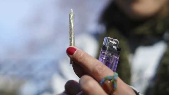 Žena drží jointa z marihuany.