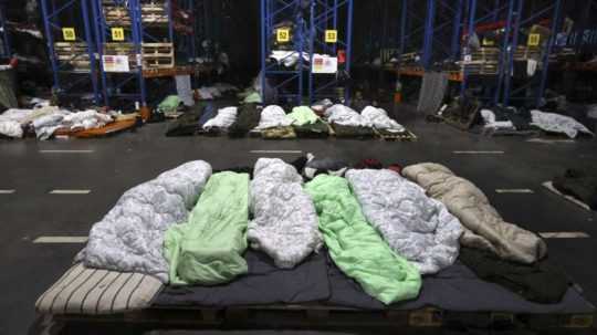 Migranti spia v logistickom centre neďaleko mesta Hrodna na bielorusko-poľských hraniciach.