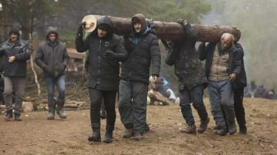 migranti pri poľsko-bieloruskej hranici nesú drevo