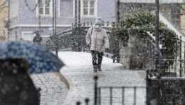 Žena kráča po ulici počas sneženia v nemeckom Vilshofene