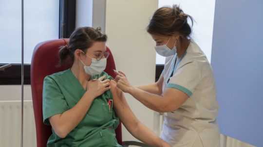 Zdravotná sestra podáva vakcínu proti ochoreniu COVID-19 od spoločnosti Moderna zdravotníčke vo vakcinačnom centre.