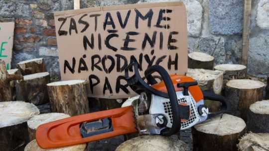 plagát a narúbané drevo počas protestu proti blokovaniu reformy národných parkov.
