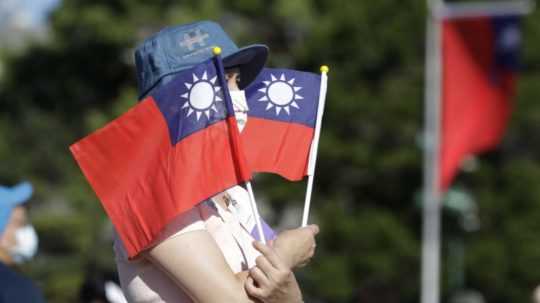 žena drží taiwanské vlajky