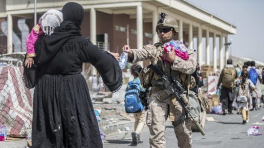 Americký vojak poskytuje vodu afganskej rodine počas evakuácie na medzinárodnom letisku Hamída Karzaja v Kábule.