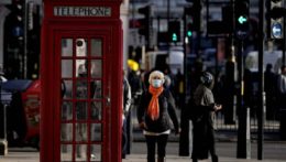 žena s rúškom kráča ulicami Londýna