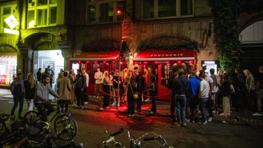 Ľudia stoja pred nočným klubom v dánskej Kodani.