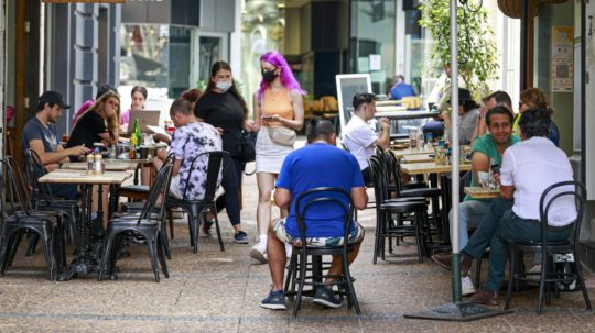 Zákazníci sedia pred kaviarňami v novozélandskom Aucklande.