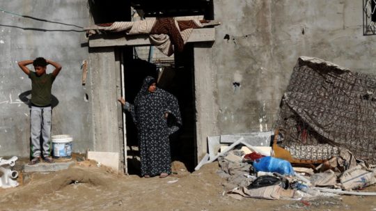 palestínska žena a jej syn stoja pred domom v chudobnej časti mesta Gaza