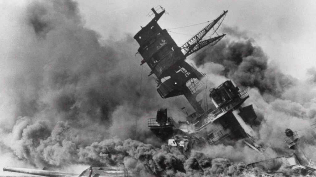 Na archívnej snímke zo 7. decembra 1941 americká bojová loď Arizona horí a ponára sa do vody počas japonského útoku na Pearl Harbor.