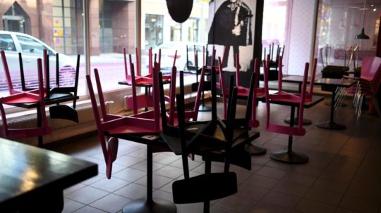 Na snímke stoličky vyložené na stoloch v zatvorenej reštaurácii.