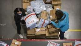 NA snímke zamestnanci čínskej pošty nakladajú balíky.