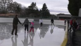 Ľudia sa korčuľujú na ľadovej ploche.