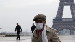Muž s ochranným rúškom kráča cez parížske prázdne námestie Trocadéro.