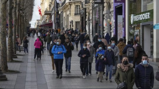 Ľudia s ochrannými rúškami kráčajúci po parížskom Champs-Élysées.